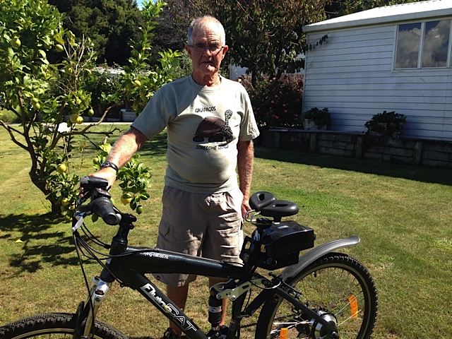 Frank from New Zealand standing with his Flying Cat e mountain bike with Spiderflex seat installed comments on comfort